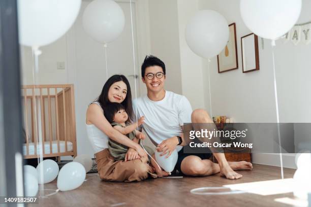 cheerful young asian family celebrating birthday at home - chinese family taking photo at home stock-fotos und bilder