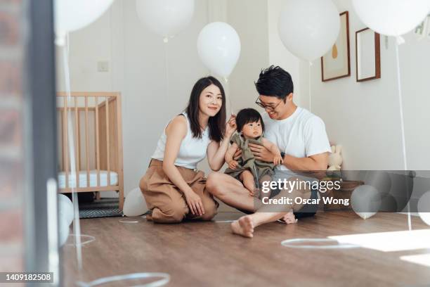 cheerful young asian family celebrating birthday at home - chinese birthday stock-fotos und bilder