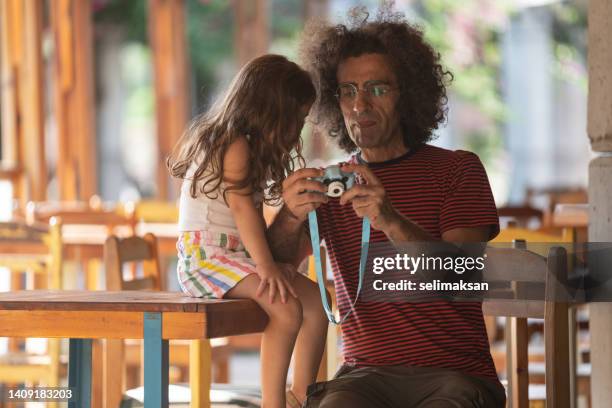 father and daughter holding a toy camera - toy camera stock pictures, royalty-free photos & images