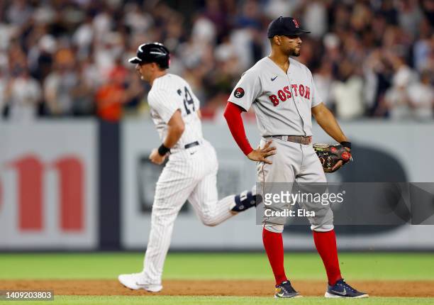 Xander Bogaerts of the Boston Red Sox reacts as Matt Carpenter of the New York Yankees rounds the bases after Carpenter hit a three run home run in...
