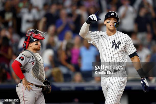 Aaron Judge of the New York Yankees celebrates his solo home run as Christian Vazquez of the Boston Red Sox reacts in the fifth inning at Yankee...