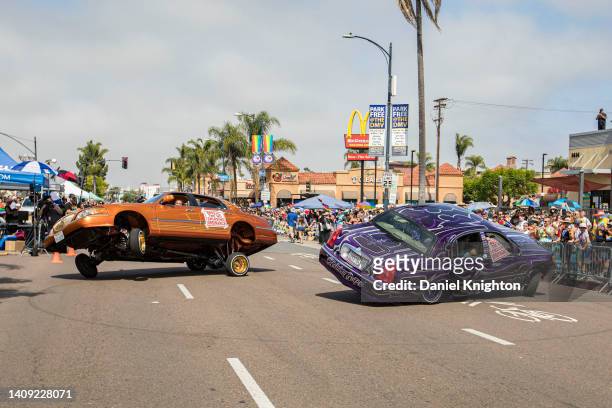 Drivers in low rider cars perform stunts for the crowd at 2022 San Diego Pride Parade on July 16, 2022 in San Diego, California.