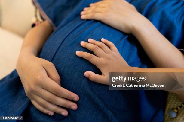 young child touching pregnant mixed-race female’s baby bump - kicking tire stock pictures, royalty-free photos & images