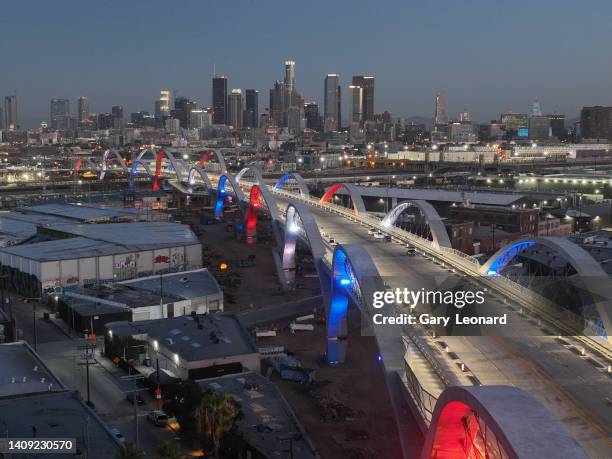 Drone view at dawn of the downtown skyline and a side angle on the bridge arches majestically lit in red white and blue during the opening of the new...