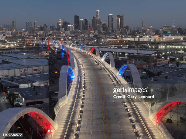Drone view at dawn of the downtown skyline and the bridge arches majestically lit in red white and blue during the opening of the new 6th Street...