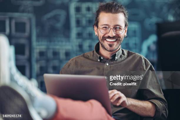 young creative professional working comfortably in a modern office - cool guy stockfoto's en -beelden