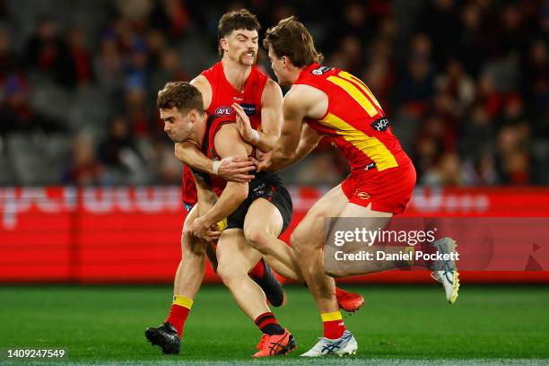 Will Snelling of the Bombers is tackled high by Sam Collins of the Suns during the round 18 AFL match between the Essendon Bombers and the Gold Coast...
