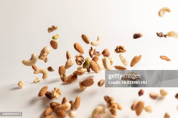 different nuts falling, walnut almonds hazelnuts pistachios cashews - pecan nut stock pictures, royalty-free photos & images