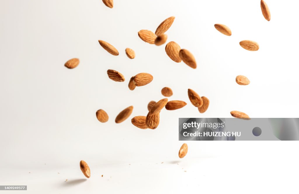 Flying almond nuts on white background