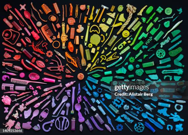 rainbow coloured arrangement of plastic items washed up on the beach - arranging ideas stock pictures, royalty-free photos & images