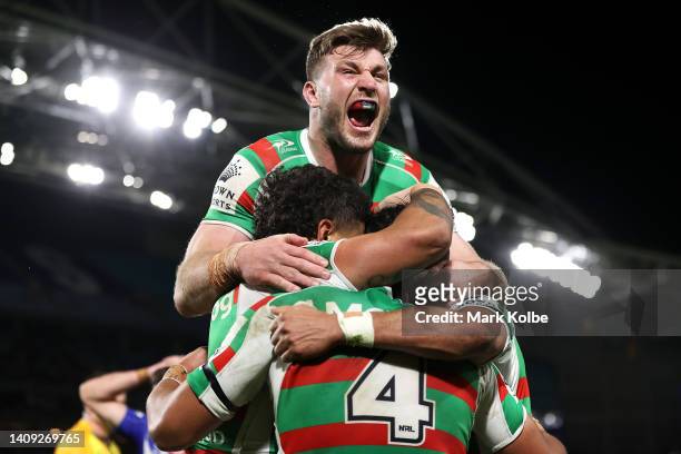 Jai Arrow of the Rabbitohs jumps on his team mates as they celebrate with Alex Johnston of the Rabbitohs after he scored a try during the round 18...