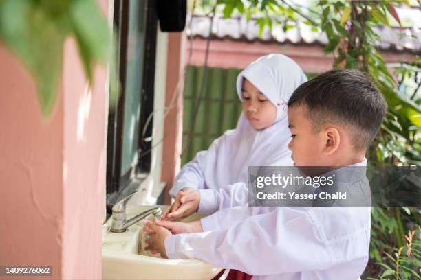 two students washing hands - child washing hands photos et images de collection