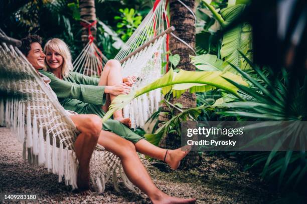 couple s’amusant dans un hamac - plante tropicale photos et images de collection
