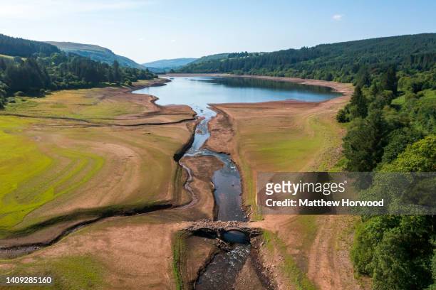 An aerial view of an exposed bridge normally underwater at the Llwyn-on Reservoir, the largest of the three reservoirs in the Taf Fawr valley on July...