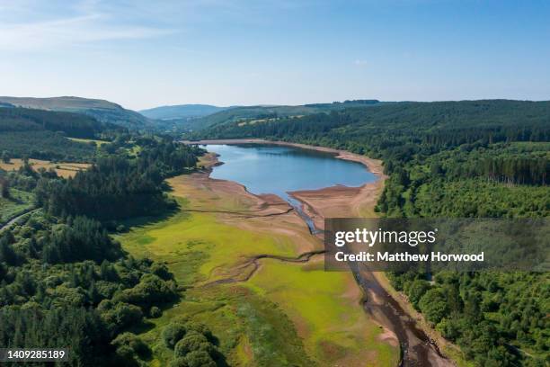 An aerial view of an exposed bridge normally underwater at the Llwyn-on Reservoir, the largest of the three reservoirs in the Taf Fawr valley on July...