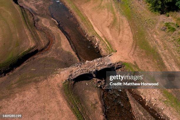 An aerial view of an exposed bridge normally underwater at the Llwyn-on Reservoir, the largest of the three reservoirs in the Taf Fawr valley on July...