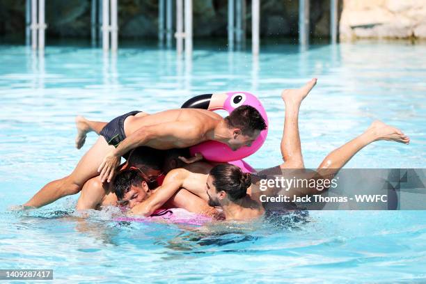 Conor Coady, Joao Moutinho, Pedro Neto and Ruben Neves jump on Raul Jimenez of Wolverhampton Wanderers while on an inflatable flamingo following a...