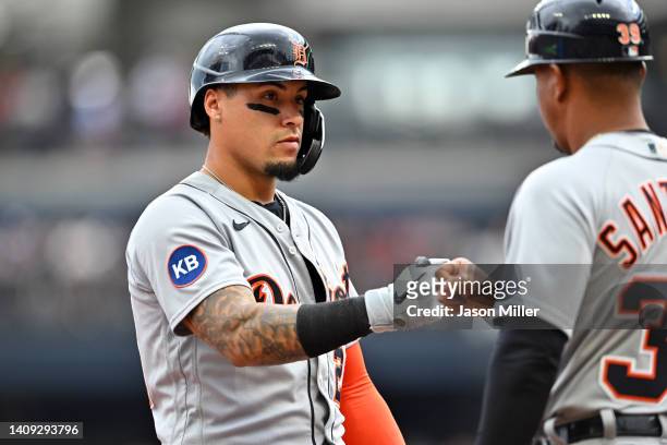 Javier Baez of the Detroit Tigers celebrates with third base coach Ramon Santiago during the first inning against the Cleveland Guardians at...