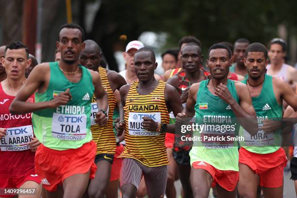 Tamirat Tola of Team Ethiopia, Fred Musobo of Team Uganda and Lelisa Desisa of Team Ethiopia compete in the Men's Marathon on day three of the World...