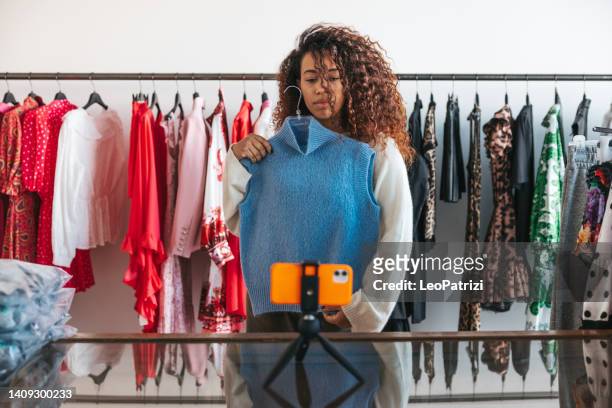woman recording a vlog in her small business retail clothing store - photo messaging stock pictures, royalty-free photos & images