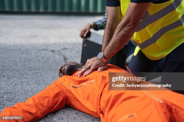 an injured dock worker was given cpr by a colleague in the dock commercial yard. - serious injury stock pictures, royalty-free photos & images