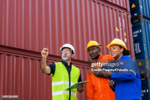dock workers working in commercial dock inspected containers - docklands studio stock pictures, royalty-free photos & images