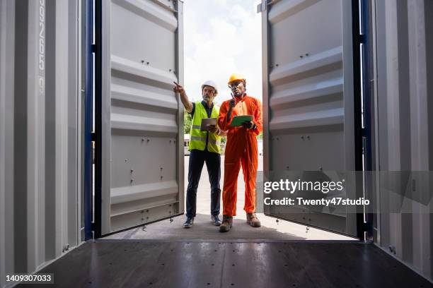 customs officer and dock worker opening the container box to check declare goods - docklands studio stock pictures, royalty-free photos & images
