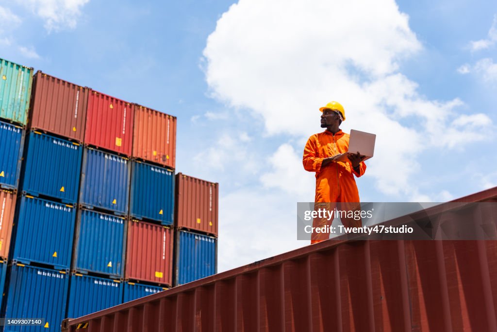 Balck worker using a laptop working in the commercial dock