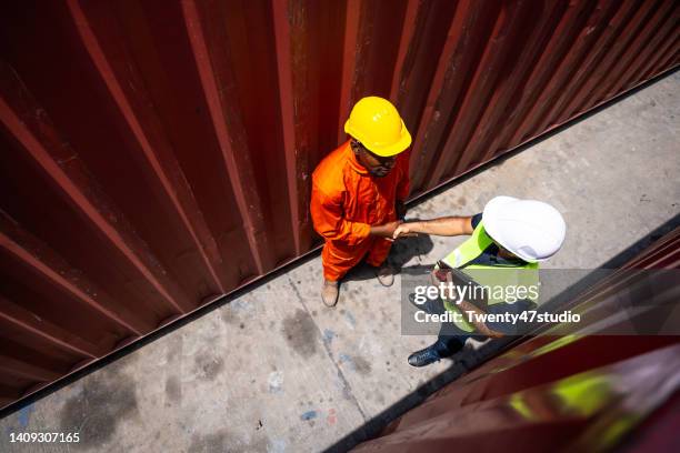 workers doing hand shake in the commercial dock - docklands studio stock pictures, royalty-free photos & images