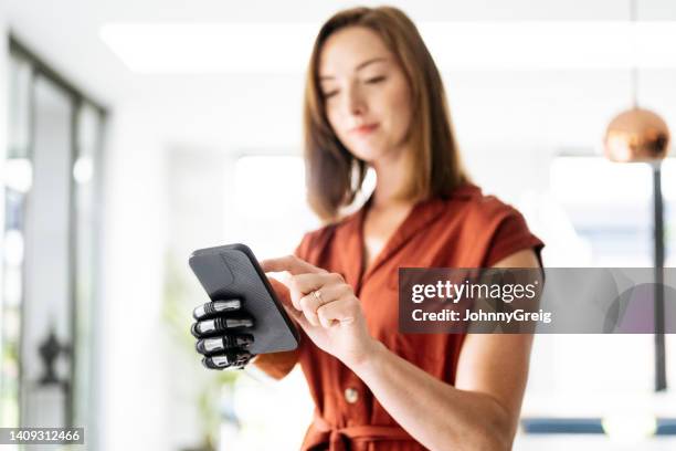 電話を使ったバイオニックアームを持つ若い女性のウエストアップビュー - bionic hand ストックフォトと画像