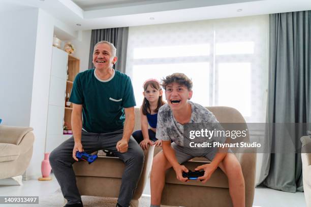 father and son competing in video games at home - game six stockfoto's en -beelden