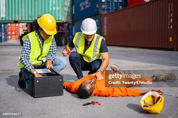 a dock worker had an accident falling down from a high section rescued by emergency staff - docklands studio stock pictures, royalty-free photos & images