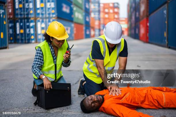 medical emergency team first aid injured dock work in the commercial dock - docklands studio stock pictures, royalty-free photos & images