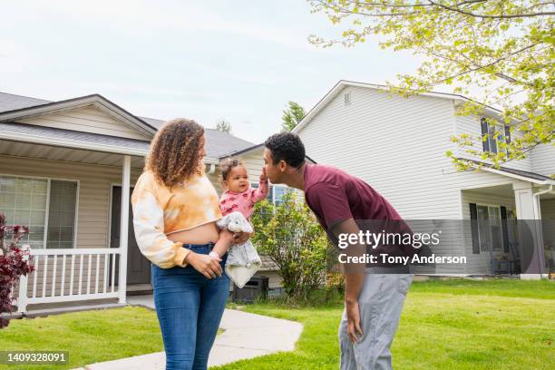 young mother and father with infant daughter outside home - new home exterior stock pictures, royalty-free photos & images