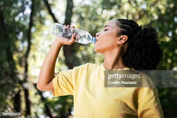 junge frau hydratisiert - woman drinking water from bottle stock-fotos und bilder