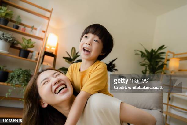 playful mother having fun while stay at home with boy. - stay indoors stock pictures, royalty-free photos & images