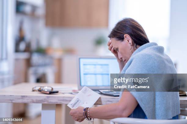 woman frustrated paying bills at home - financial fear stock pictures, royalty-free photos & images