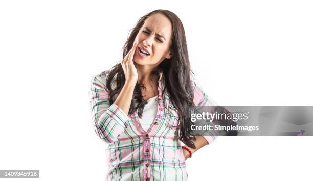 severe toothache in a woman touching a sensitive area. isolated on white. - toothache stock pictures, royalty-free photos & images