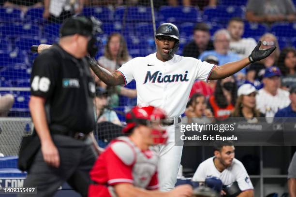Jorge Soler of the Miami Marlins disagrees with home plate umpire Ron Kulpa about a strike call while Bryan De La Cruz is batting in the ninth inning...