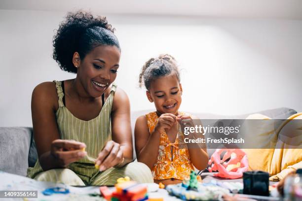 mother and daughter playing with a playdough - babysit stockfoto's en -beelden