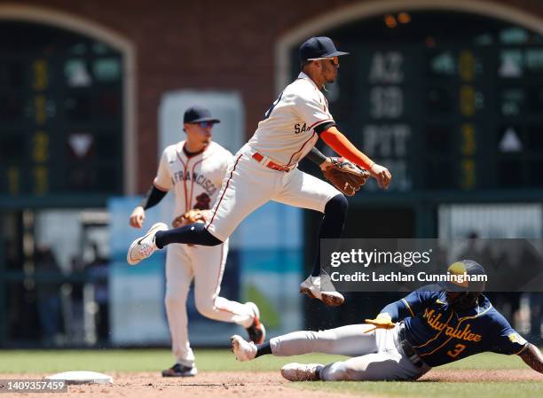 Thairo Estrada of the San Francisco Giants gets the out at second base of Jonathan Davis of the Milwaukee Brewers and throws to first base to turn a...