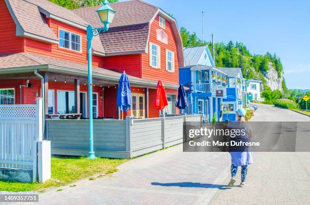 woman walking on street of village - quebec road stock pictures, royalty-free photos & images