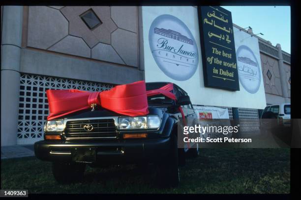Sport utility vehicles wrapped like Christmas gifts are on display in front of a shopping mall December 20, 1996 in Dubai, United Arab Emirates....