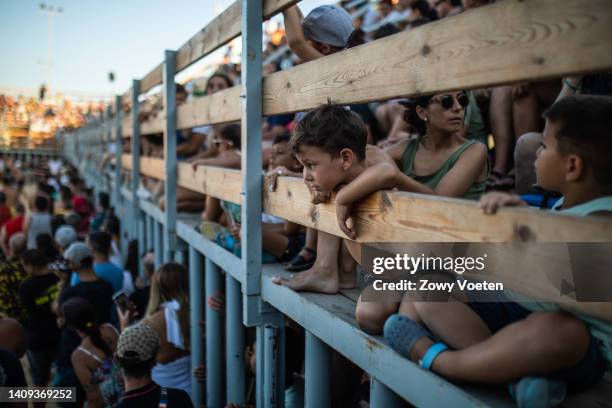 Boy leans against the fence to watche a bullfight during the 'Bous a la Mar' festival on July 17, 2022 in Denia, Spain. The bull-evading event at...