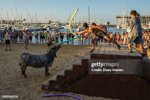 Bull makes participants of the running of the bulls fall into the sea during the 'Bous a la Mar' festival on July 17, 2022 in Denia, Spain. The...