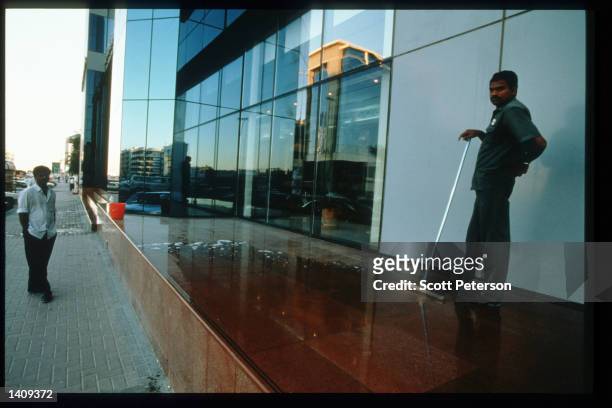 Migrant workers clean modern buildings December 20, 1996 in Dubai, United Arab Emirates. Since the 1960s the UAE has progressed from a largely...