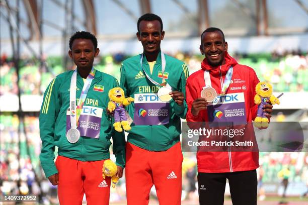 Silver medalist Mosinet Geremew of Team Ethiopia, gold medalist Tamirat Tola of Team Ethiopia and bronze medalist Bashir Abdi of Team Belgium pose...