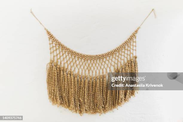 hand made natural cotton macrame decoration hanging on white wall. - macrame stock pictures, royalty-free photos & images