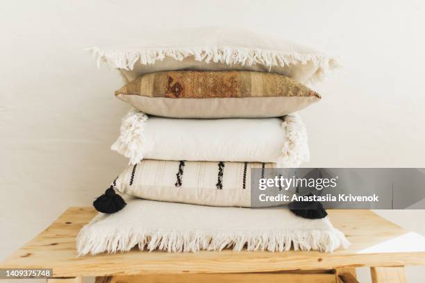 boho pillows on wooden chair against white wall background. - cushion stock pictures, royalty-free photos & images