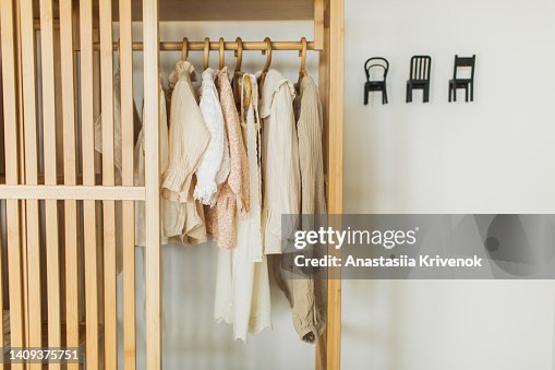 Neatly hung clothes on hangers in wooden closet. Neatly hung clothes on hangers in wooden closet.